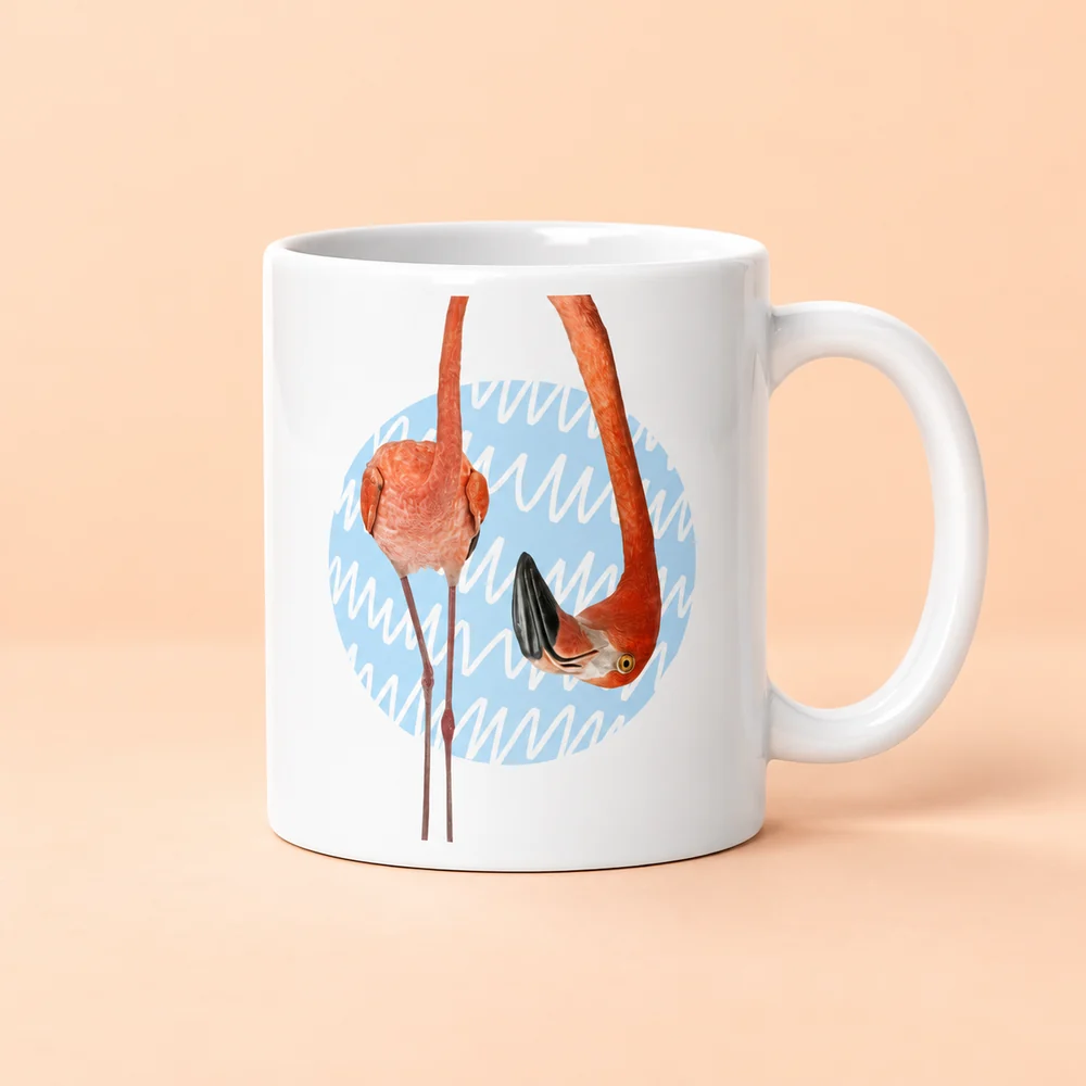 A glossy ceramic mug with a playful flamingo design